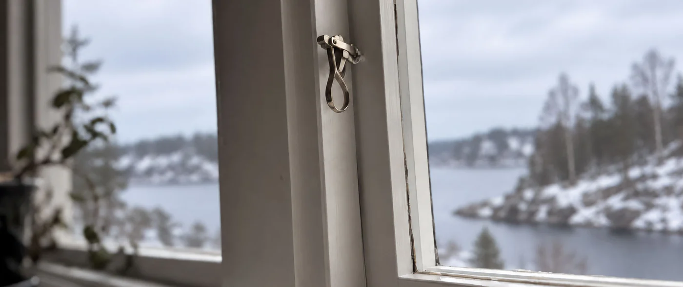 Kopplat tvåglasfönster i trä med utsikt över vinterskärgården i Nacka